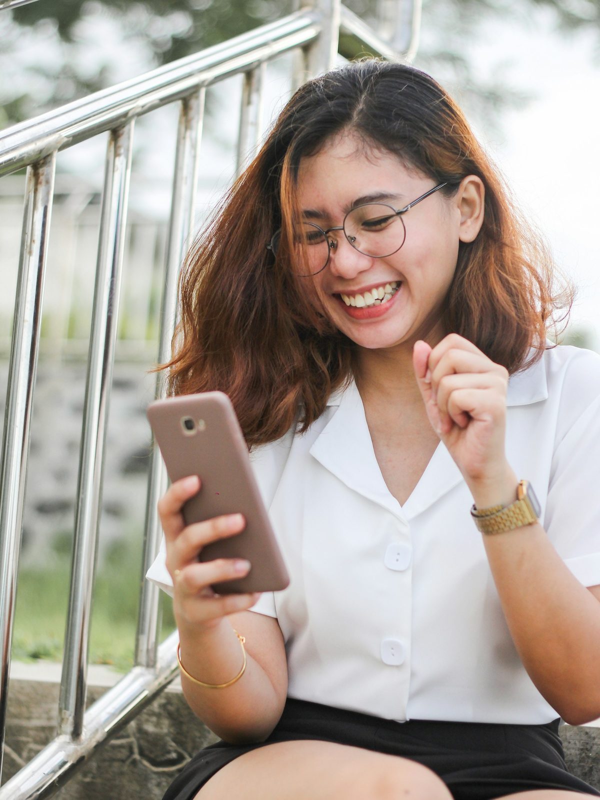 A happy customer laughing as she uses her repaired phone